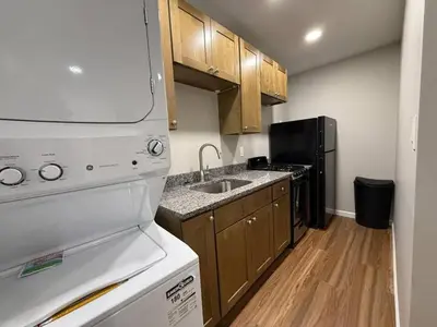 a small kitchen with a sink and a refrigerator at Cozy Cottages Flexible Stays in Wrightsville