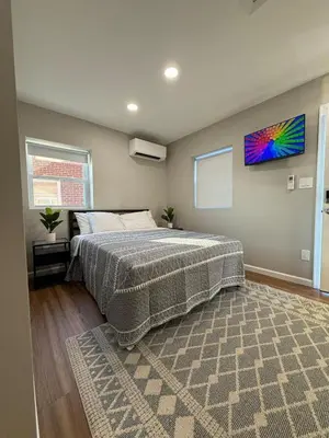 a bedroom with a large bed and a rug at Cozy Cottages Flexible Stays in Wrightsville