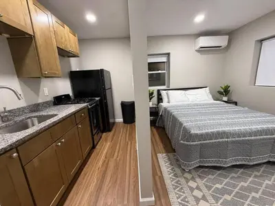 a bedroom with a bed and a sink in a room at Cozy Cottages Flexible Stays in Wrightsville