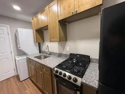 a small kitchen with a stove and a sink at Cozy Cottages Flexible Stays in Wrightsville