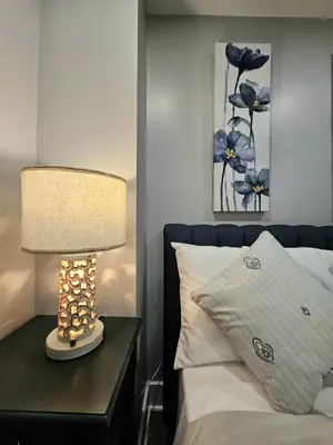 a lamp on a table next to a bed at Curacao vs Ivory Coast, Lock in NOW! Sleeps 14 in Philadelphia