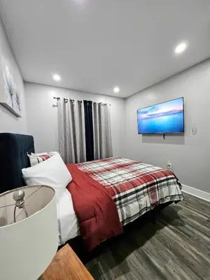 a bedroom with a bed and a flat screen tv at Curacao vs Ivory Coast, Lock in NOW! Sleeps 14 in Philadelphia