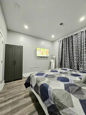 a bedroom with a bed and a tv on the wall at Curacao vs Ivory Coast, Lock in NOW! Sleeps 14 in Philadelphia