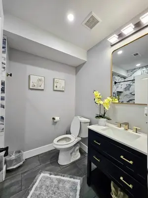a bathroom with a toilet and a sink and a mirror at Curacao vs Ivory Coast, Lock in NOW! Sleeps 14 in Philadelphia
