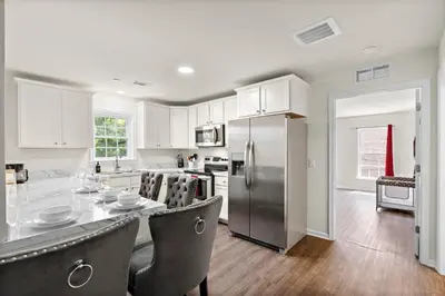 a kitchen with white cabinets and a stainless steel refrigerator at 7 guests NYC-NWK Free parking in Newark