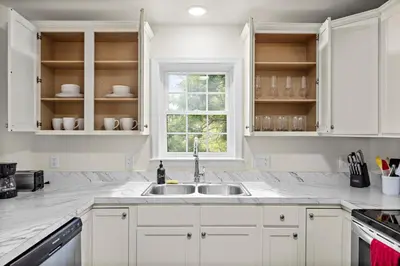 a white kitchen with a sink and a window at 7 guests NYC-NWK Free parking in Newark