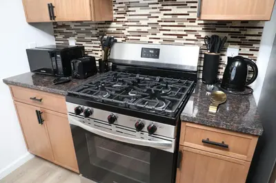 a kitchen with a stove top oven in a kitchen at Modern Minimalist Lux Paradise in Newark
