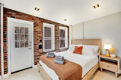 a bedroom with a bed and a brick wall at SoHo Designer 2BR with balcony in New York