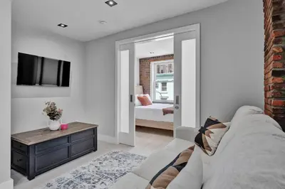a living room with a couch and a tv and a bedroom at SoHo Designer 2BR with balcony in New York
