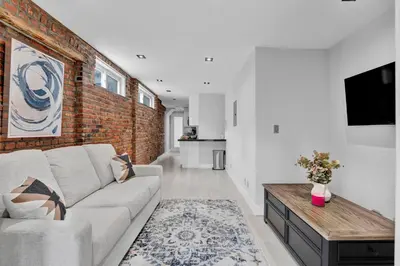 a living room with a couch and a brick wall at SoHo Designer 2BR with balcony in New York