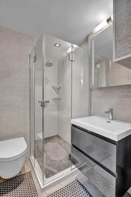 a bathroom with a shower and a toilet and a sink at SoHo Designer 2BR with balcony in New York