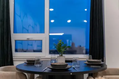 a black table with plates and glasses and a window at Luxury Lookout with NYC view, 2BR plus Free Parking, Sleeps 8, 20 Percent Off in East Orange
