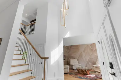 a hallway with white walls and stairs with a toilet at Malkita Terra -Earthly Elegance in Woodbury