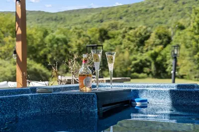 a bottle of champagne and two glasses on a table in a pool at Malkita Terra -Earthly Elegance in Woodbury