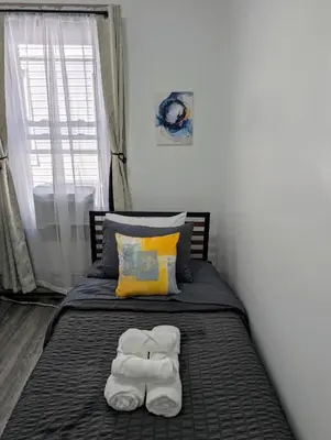 a bed with two towels on top of it at Spacious duplex retreat in city w/ Parking nearby in Jersey City