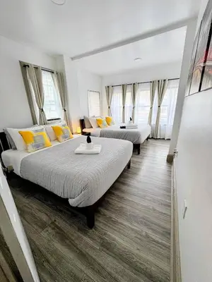 two beds in a room with windows at Spacious duplex retreat in city w/ Parking nearby in Jersey City