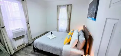 a small bedroom with a bed and a window at Spacious duplex retreat in city w/ Parking nearby in Jersey City