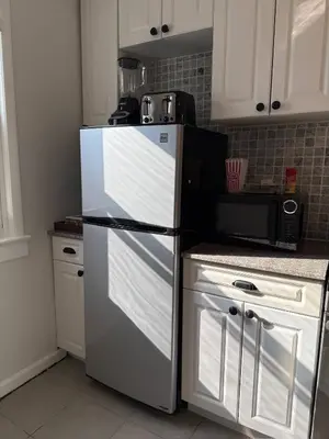 a kitchen with a refrigerator and a microwave at Sunset Slopes in Jersey City