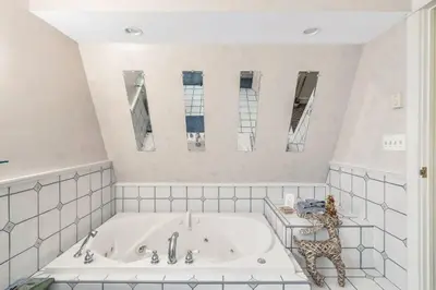 a white bathroom with a tub and two mirrors at Quiet Getaway with Queen Bed & Wi-Fi in Clarks Summit