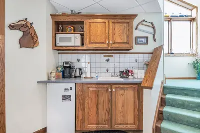 a small kitchen with wooden cabinets and a white refrigerator at Clarks Summit Gem w/ Private Yard & Parking in Clarks Summit