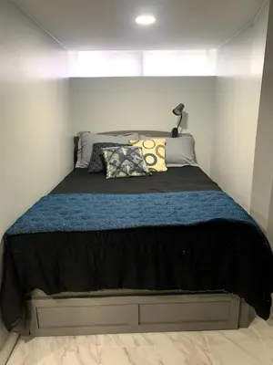 a bedroom with a large bed with a blue blanket at A Cozy Corner with kitchen and parking in Drexel Hill