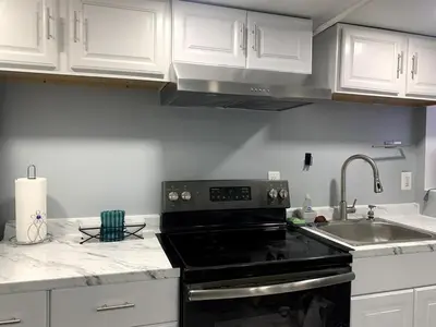 a kitchen with a black stove and a sink at A Cozy Corner with kitchen and parking in Drexel Hill