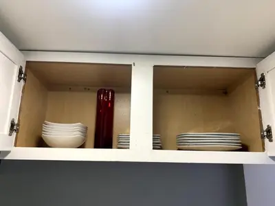 a cabinet with plates and bowls and a red vase at A Cozy Corner with kitchen and parking in Drexel Hill