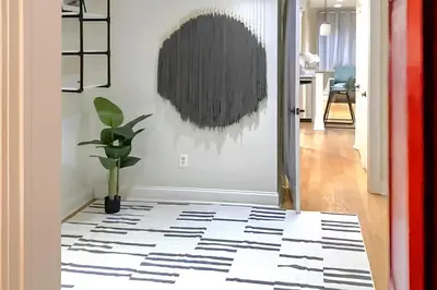 a hallway with a black and white patterned floor at Corporate Housing, Upgraded Condo Downtown Hoboken in Hoboken