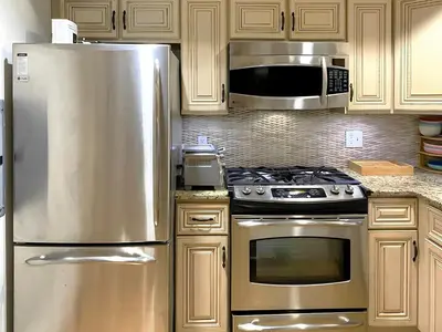 a kitchen with a stainless steel refrigerator and a microwave at Corporate Housing, Upgraded Condo Downtown Hoboken in Hoboken