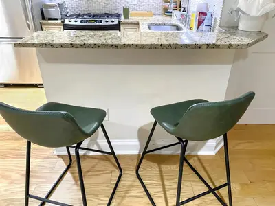 two green chairs sitting at a kitchen counter at Corporate Housing, Upgraded Condo Downtown Hoboken in Hoboken