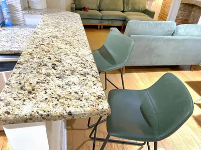 a kitchen counter with two chairs and a table at Corporate Housing, Upgraded Condo Downtown Hoboken in Hoboken