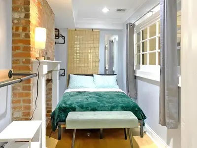 a bedroom with a bed with a green blanket at Corporate Housing, Upgraded Condo Downtown Hoboken in Hoboken