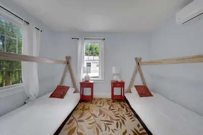 two beds in a room with a window at Cozy Cottage House - Pool & Hot Tub in Liberty