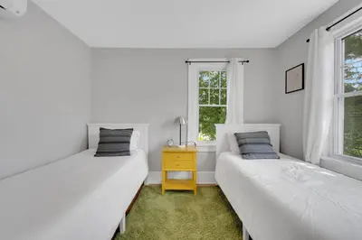 two beds in a white room with a window at Cozy Cottage House - Pool & Hot Tub in Liberty