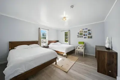 a bedroom with two beds and a chair at Liberty Lakefront Home - Pool, Hot Tub, Sauna in Liberty