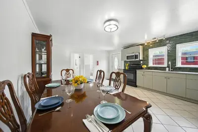 a dining room with a table and a kitchen at Liberty Lakefront Home - Pool, Hot Tub, Sauna in Liberty