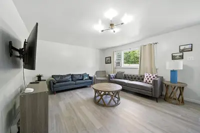 a living room with a couch and a table at Liberty Lakefront Home - Pool, Hot Tub, Sauna in Liberty