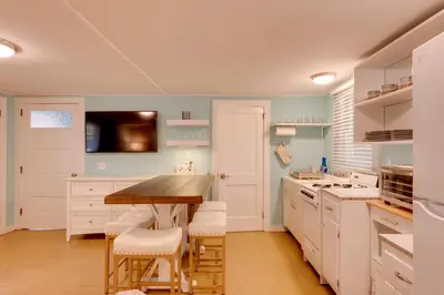 a kitchen with a wooden table and white cabinets at Fish and Hike Lakeside Poconos Retreat, Unit 4 in Bangor