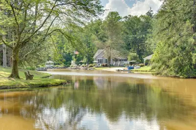 a river with houses and trees in the background at Fish and Hike Lakeside Poconos Retreat, Unit 4 in Bangor