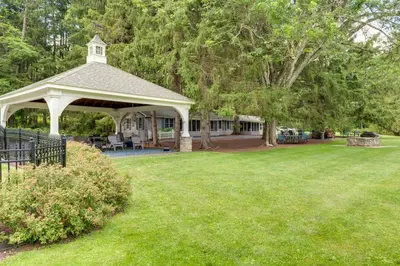a white gazebo in a yard with trees at Fish and Hike Lakeside Poconos Retreat, Unit 4 in Bangor