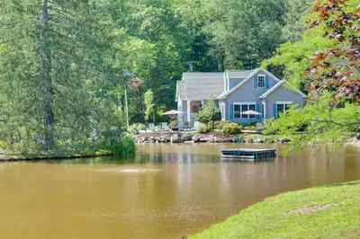 a house sitting on a river with a house at Fish and Hike Lakeside Poconos Retreat, Unit 4 in Bangor