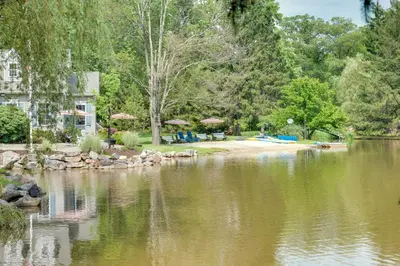 a view of a lake with a house and trees at Fish and Hike Lakeside Poconos Retreat, Unit 3 in Bangor