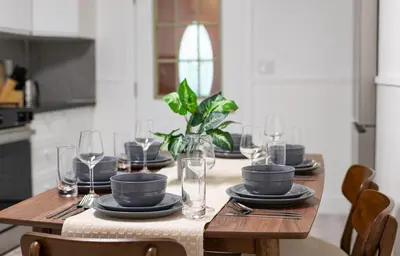 a wooden table with plates and wine glasses on it at 15m to NY Cozy Relaxing Home in Hackensack