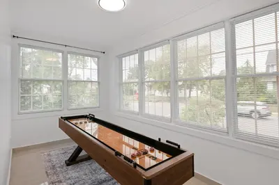 a room with a foosball table in front of windows at 15m to NY Cozy Relaxing Home in Hackensack