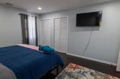 a bedroom with a bed and a flat screen tv on the wall at New 3 Bed & 1 Bed Apt Lake Park Station EWR Airport Path Train Subway Bus Hospital Rahway NJ Manhattan NYC in Rahway