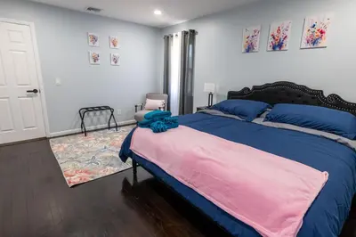 a bedroom with a large bed with blue and pink sheets at New 3 Bed & 1 Bed Apt Lake Park Station EWR Airport Path Train Subway Bus Hospital Rahway NJ Manhattan NYC in Rahway