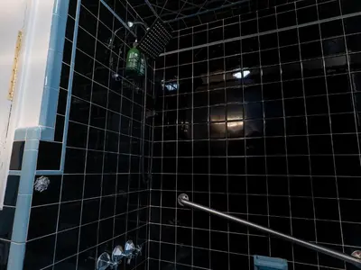 a black tiled shower with a green bottle in it at New 3 Bed & 1 Bed Apt Lake Park Station EWR Airport Path Train Subway Bus Hospital Rahway NJ Manhattan NYC in Rahway