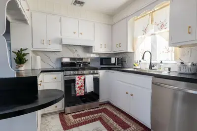 a kitchen with white cabinets and a red rug on the floor at New 3 Bed & 1 Bed Apt Lake Park Station EWR Airport Path Train Subway Bus Hospital Rahway NJ Manhattan NYC in Rahway