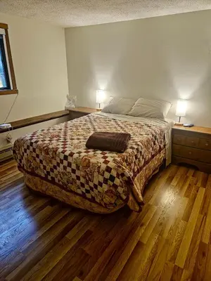 a bedroom with a bed with a blanket and two lamps at Rustic Mountain Escape Waterpark, Ski & Views! in Tannersville