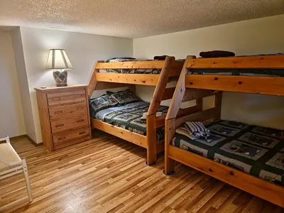 a bedroom with two bunk beds and a night stand at Rustic Mountain Escape Waterpark, Ski & Views! in Tannersville